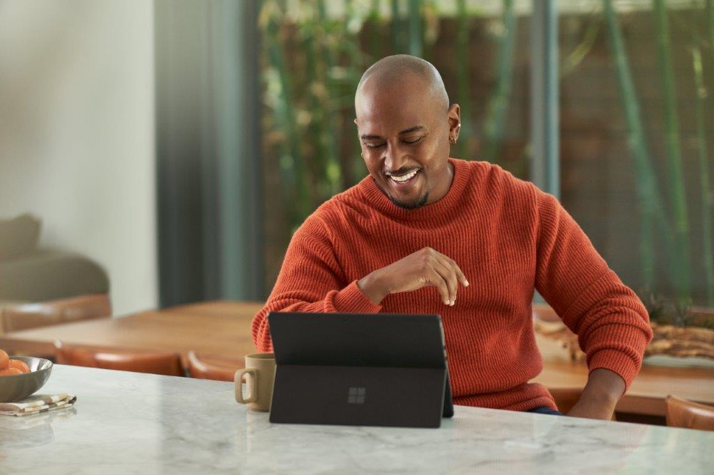 a person sitting at a table using a laptop