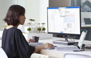 a person sitting at a desk in front of a laptop computer