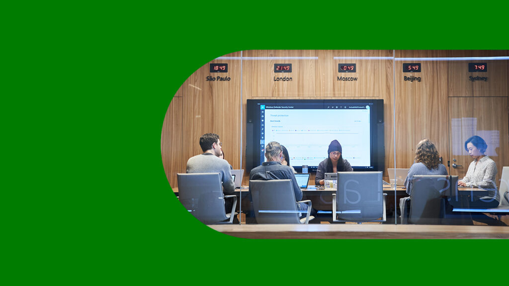 Looking into a conference room or board room meeting including people sitting around table in a room with international time clocks.