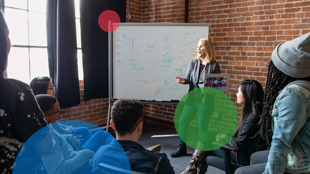 A woman standing in front of a whiteboard giving a presentation.