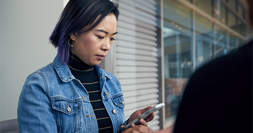 An image of a woman reading message on her phone.