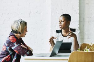 Female financial advisor in discussion with client in office conference room.