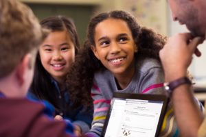 A group of students working with their teacher, with Microsoft Teams on the screen.