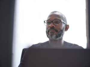 Man with glasses looking ahead.