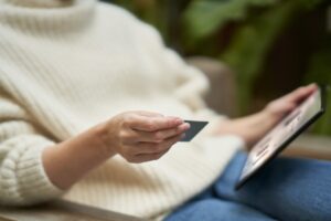 Woman using a credit card to place a secure online order from tablet.