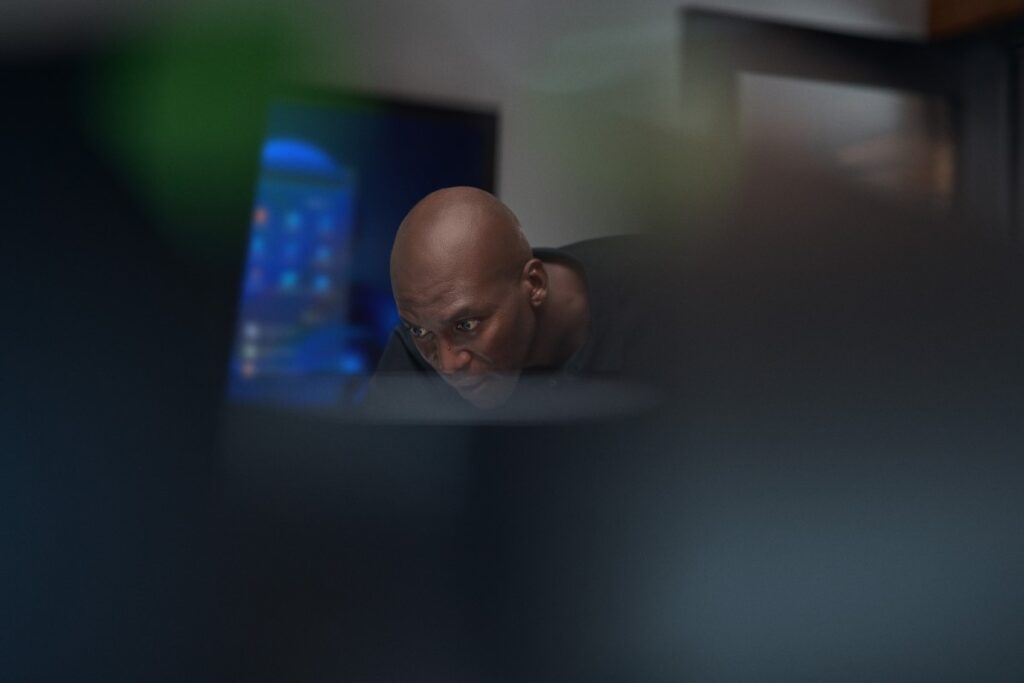 Employee leaning down, working at computer station.