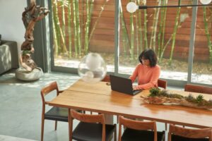 Overhead view of business decision maker working from home on a laptop.