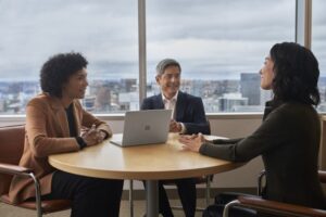 Hybrid employees collaborating on a shared device.