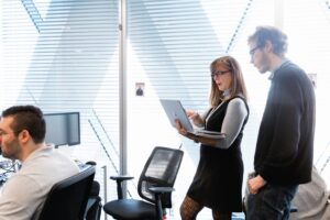 Coworkers standing in open office space.