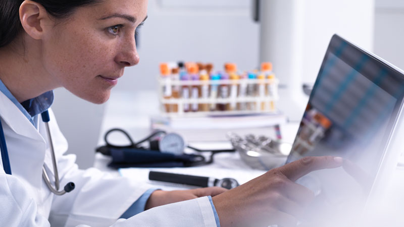 Doctor accessing a patients details using a touch screen computer in the clinic