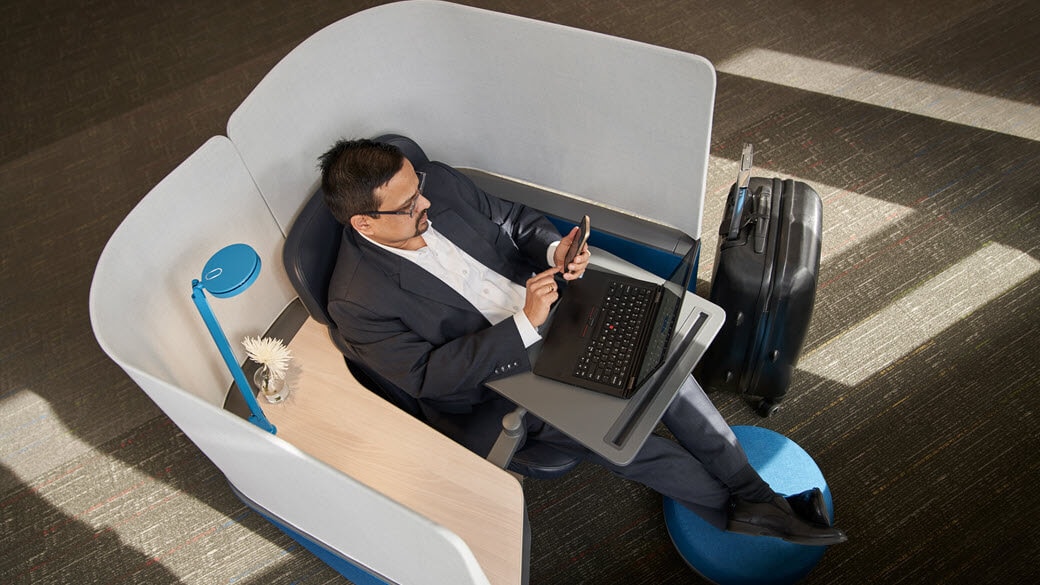 A Microsoft employee works in a cubby in a Microsoft office.