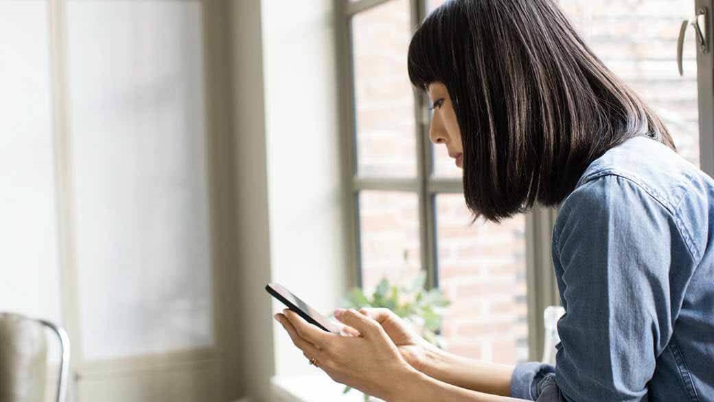 A businesswoman using a phone in a family room.