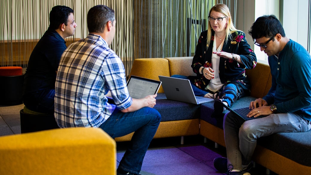 Small group of tech workers meeting in a work open space.