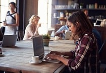 Interior Of Coffee Shop With Customers Using Digital Devices