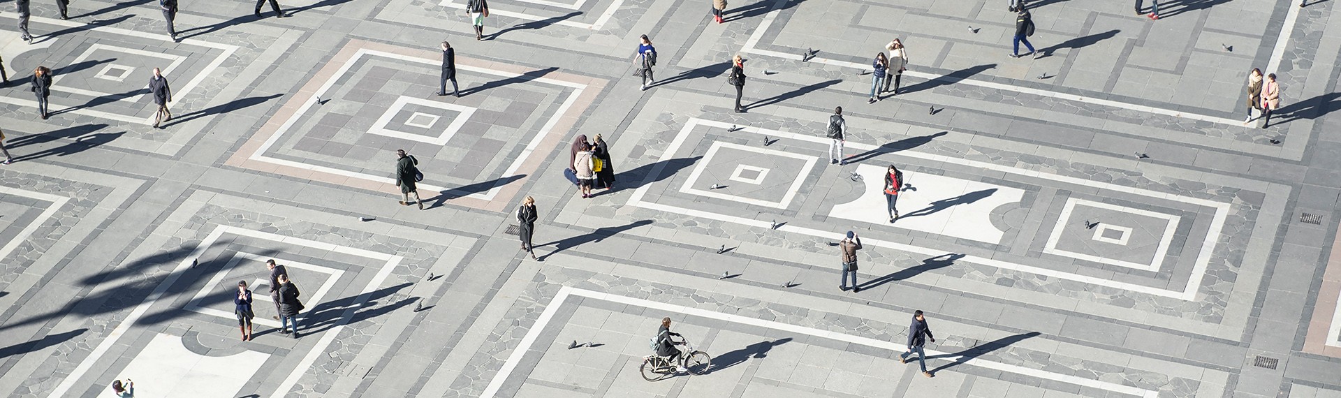 A group of people walking on a sidewalk.