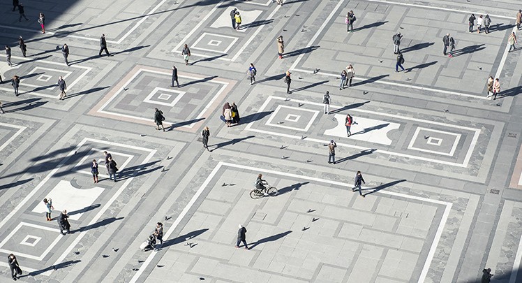 A group of people walking in a square.