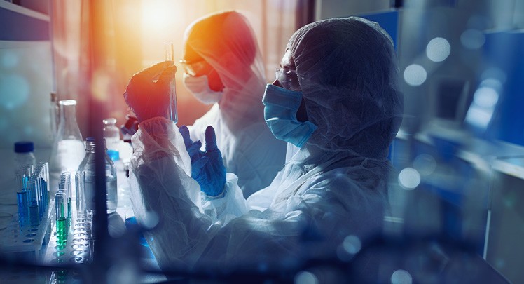 Two people in protective suits working in a laboratory.