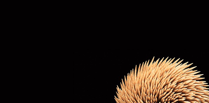 A close up of a stick of wood against a black background.