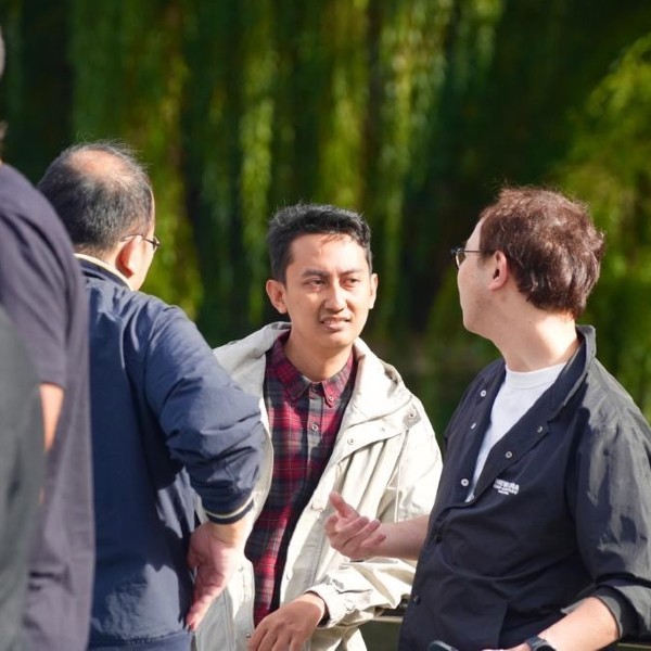 A group of people talking to each other in a park.