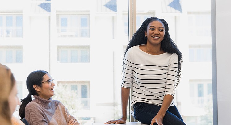 A group of women sitting around a table in a conference room.