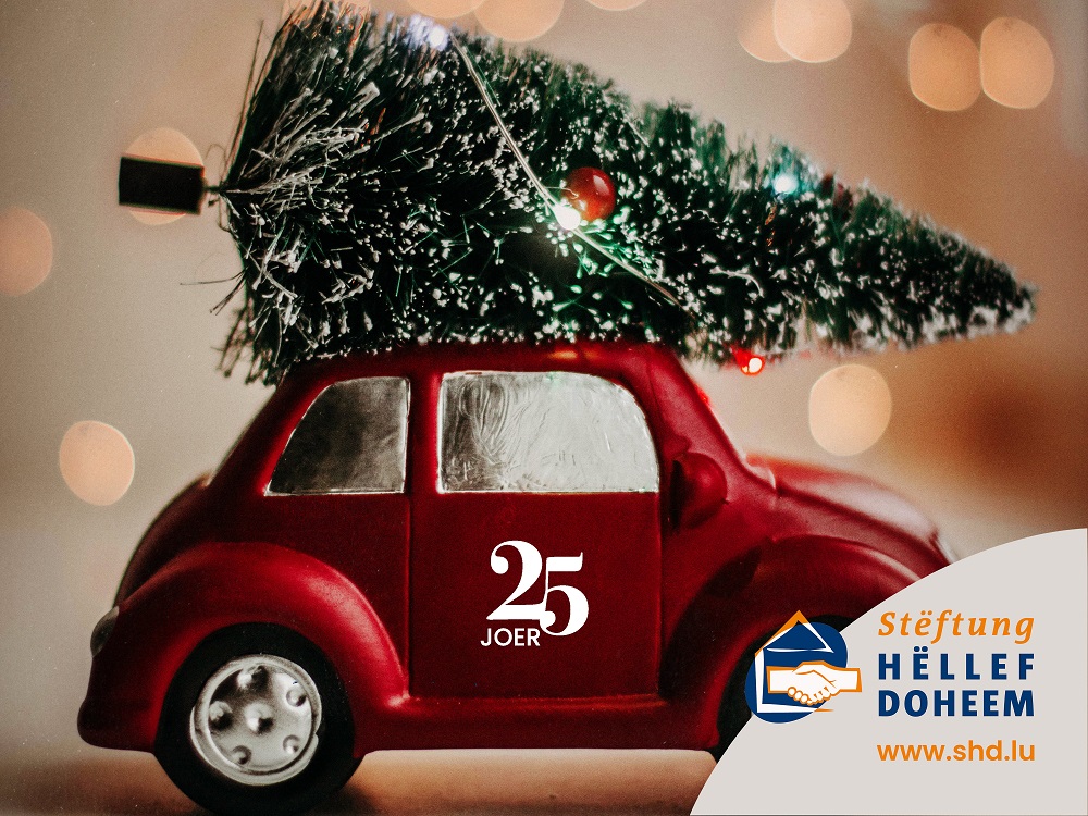 Voiture avec arbre de noel sur le toit, logoté 25 ans Stëftung Hëllef Doheem.