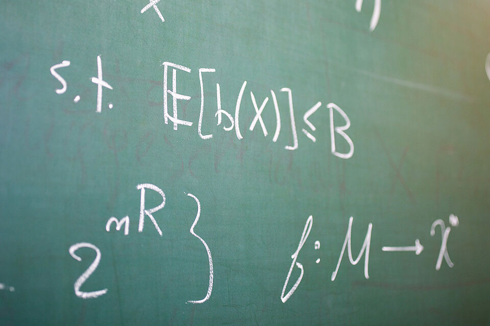 Formulas written in chalk on a green blackboard