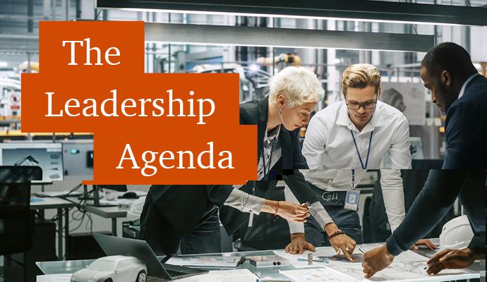 Photograph of three coworkers standing around a table  with the words "The Leadership Agenda" superimposed