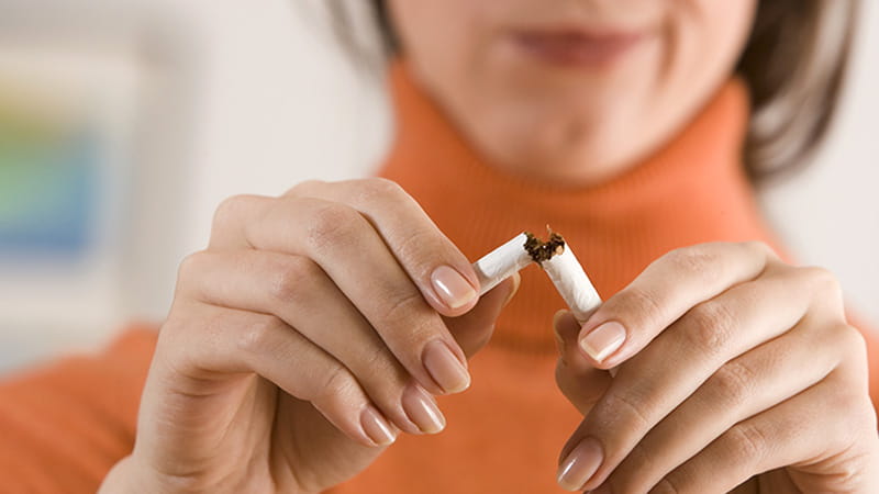 A close-up of a woman breaking a cigarette.