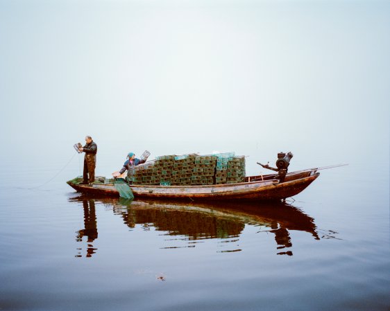 Chinese man shrimp fishing from his boat at Lake Hong