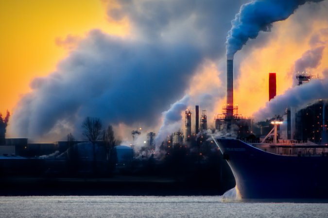 Emissions from plant and ship streaming into the air.