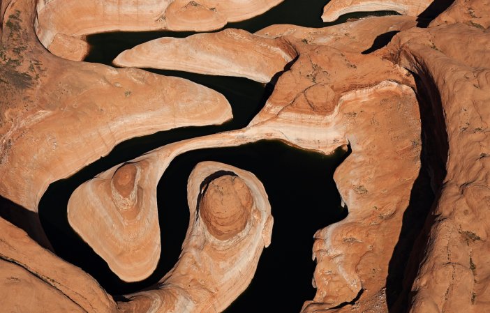 Colorado River low water levels after drought and evaporation in Lake Powell, Utah, seen from above