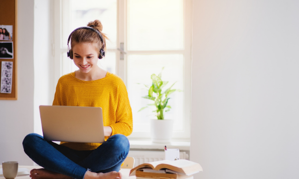 Young student on laptop with headphones