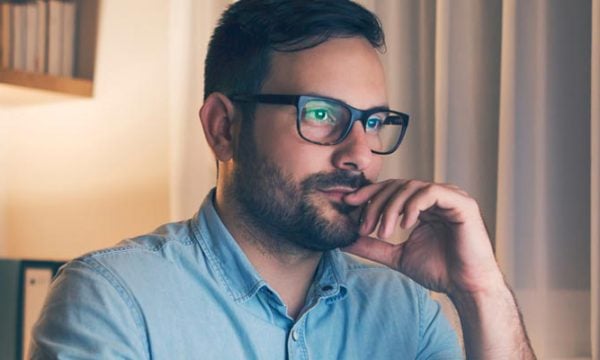 Man in glasses staring at computer screen