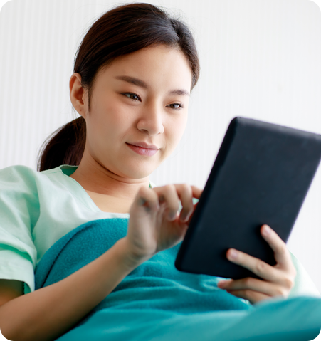 Girl using tablet to fill out paperwork in hospital bed