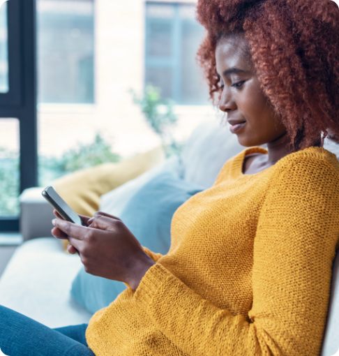 Female looking at phone and booking an appointment using Phreesia's self-scheduling tool