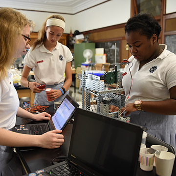 3 Computer science students engaged in a hands on activity. 