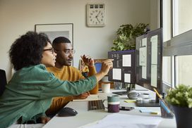 Man and woman looking at data on computers