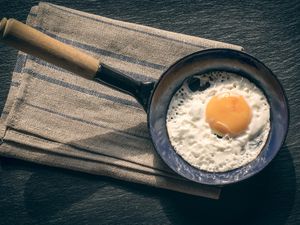 Fried egg in pan and tablecloth