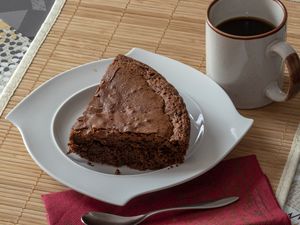 Chocolate cake on a plate with a mug of coffee