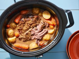 A slow cooker with onion soup beef pot roast, with potatoes and carrots