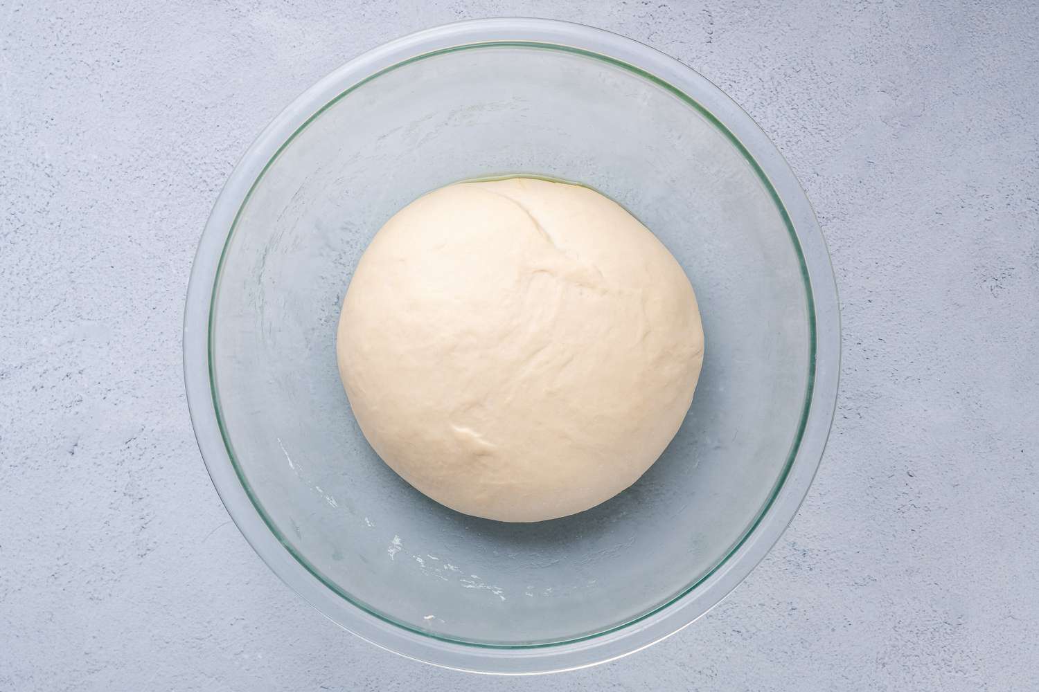 Smooth dough sitting in a greased bowl