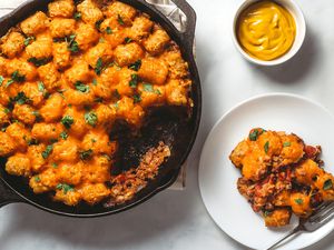 Cheeseburger Casserole in a cast iron skillet and on a plate, with a side of mustard