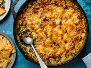 Cottage cheese spinach artichoke dip served in a cast iron skillet, served with pita chips