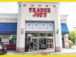 A Trader Joe's storefront with people entering the store. 