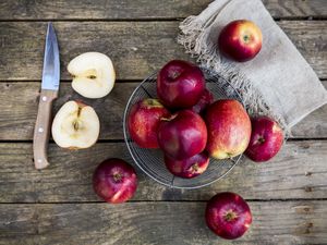 Red apples in basket on dark wood