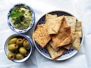 Toasted pita chips with dip and olives