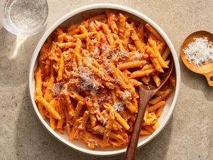 A large bowl of penne alla vodka topped with parmesan cheese