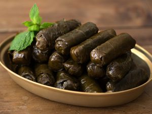 Vine leaf dolmades on a wooden table