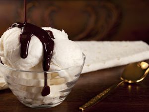 Vanilla ice cream with chocolate syrup, gold spoon