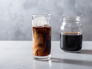 Cold Brew Concentrate in a glass with ice and in a jar 